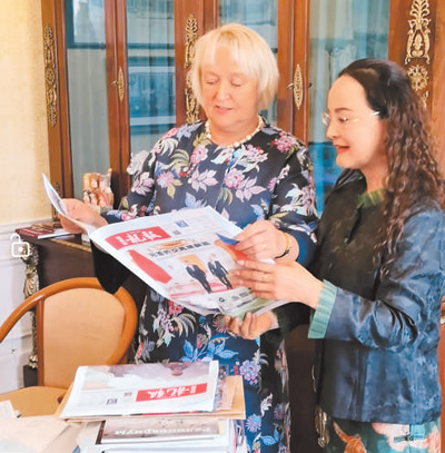 李雙杰（右）向俄羅斯友人展示《龍報》。